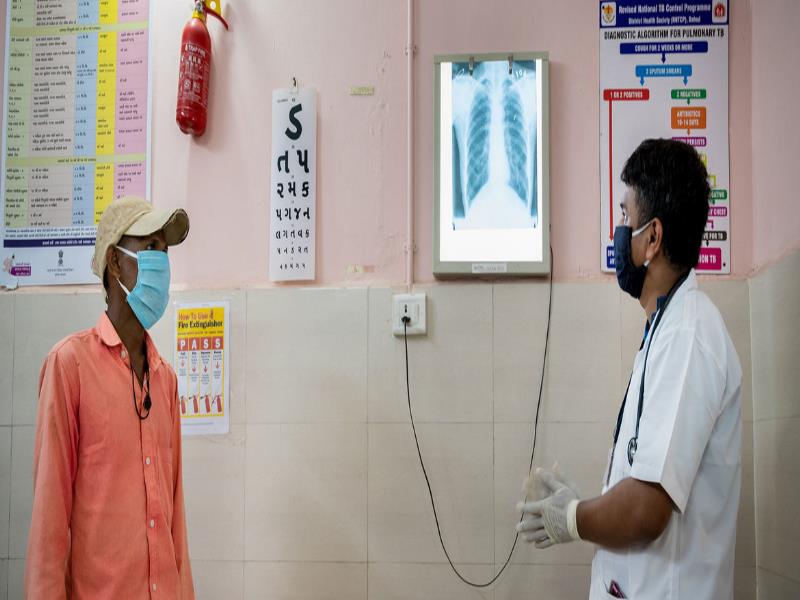 © UNICEF/Vinay Panjwani. Un doctor en la India revisa la radiografía de un paciente para buscar señales de tuberculosis