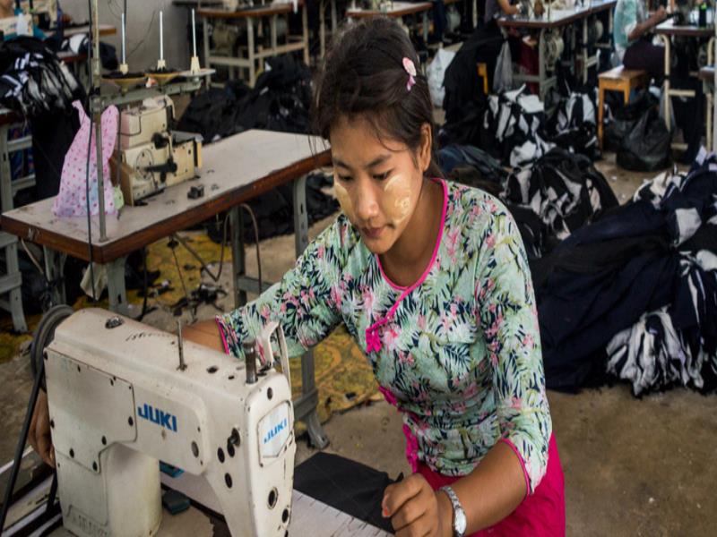 ONU Mujeres/Piyavit Thongsa-Ard Trabajadora migrante en una fábrica de ropa en Tailandia. Su jornada laboral es de doce horas y no gana siquiera el salario mínimo diario