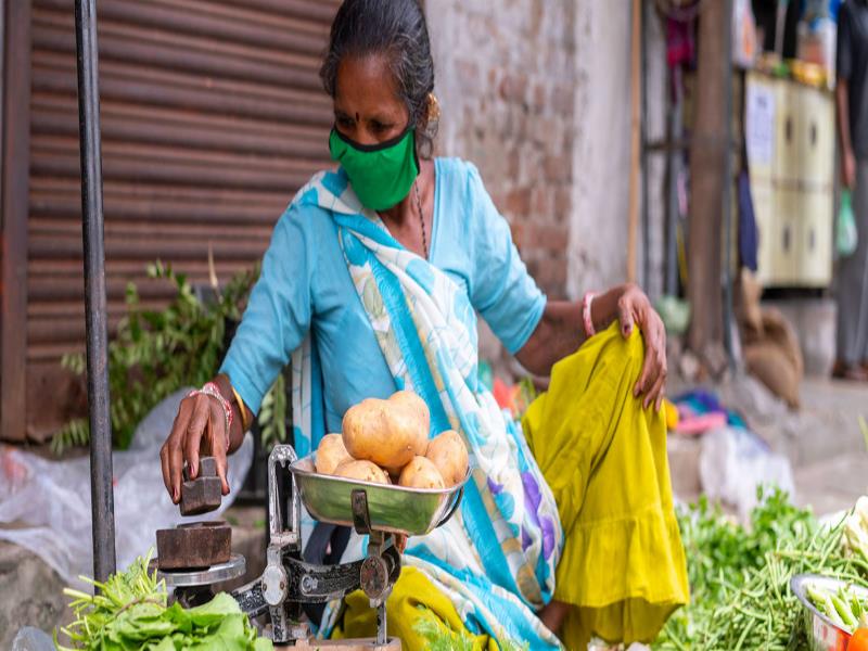  UNICEF/Vinay Panjwani. Esta vendedora callejera de verduras en la India porta una mascarilla para protegerse del COVID-19