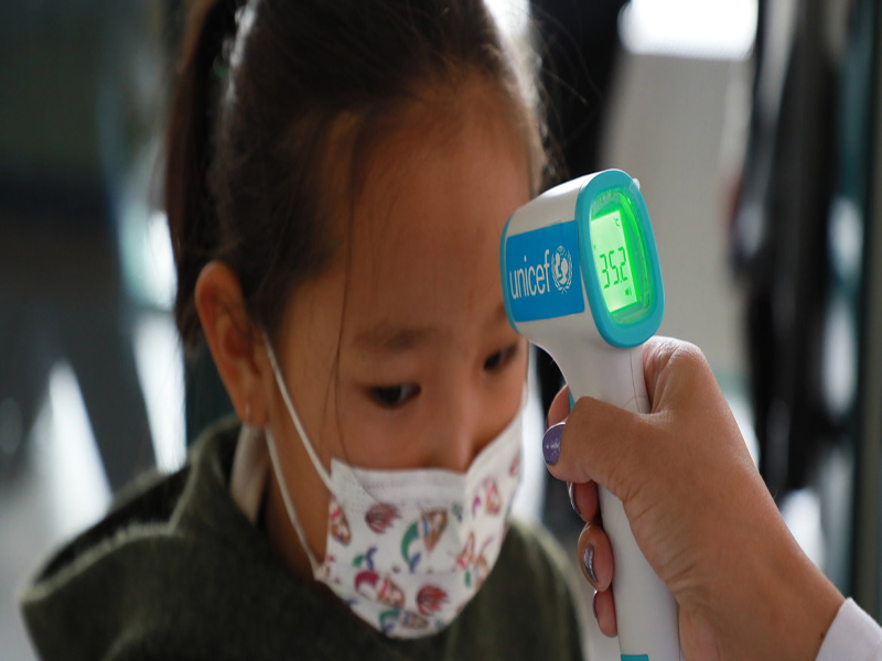 UNICEF/Chuluunbaata. Toman la temperatura a una niña pequeña en Mongolia con un termómetro proporcionado por UNICEF para prevenir los contagios de COVID-19