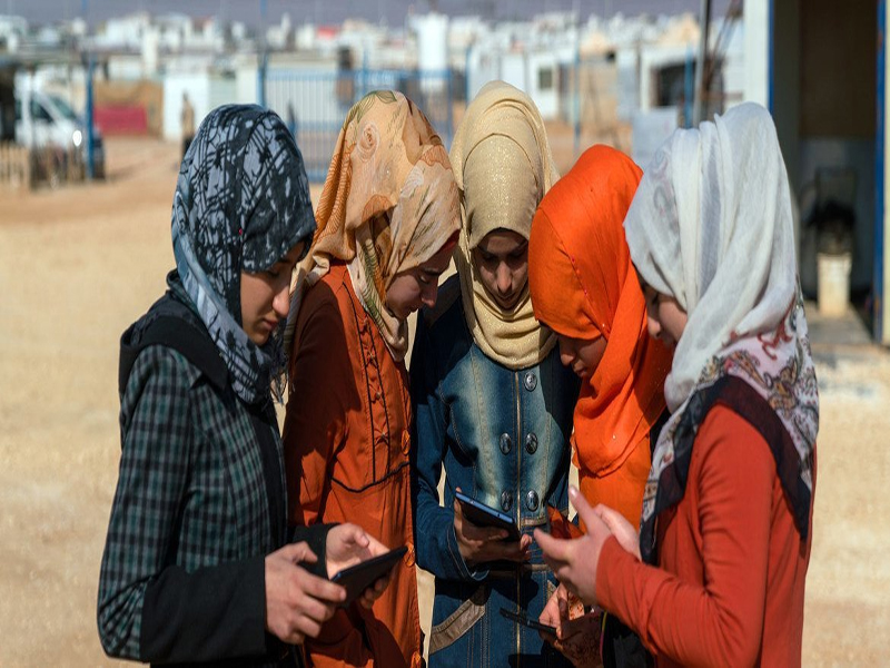 © UNICEF/UN051302/Herwig. Adolescentes usando teléfonos celulares y tabletas digitales en el campamento de refugiados sirios de Za´atari. (Foto de archivo)