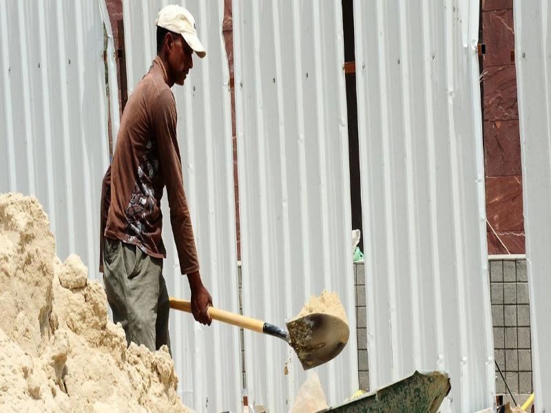 OIT/Apex Image. Un trabajador de la construcción palea arena