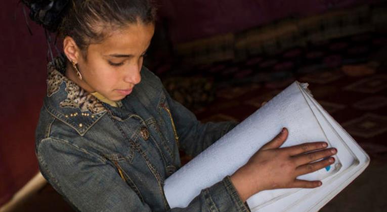 Rafah, de 12 años, practica la lectura de Braille en el refugio de su familia en el asentamiento de tiendas Fayda, en el valle de Bekaa (Líbano, 2014). Foto © ACNUR/Andrew McConnell