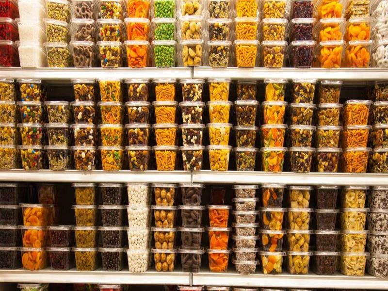 © Unsplash/Kurt Cotoaga. Contenedores con un surtido de caramelos en la estantería de una tienda.